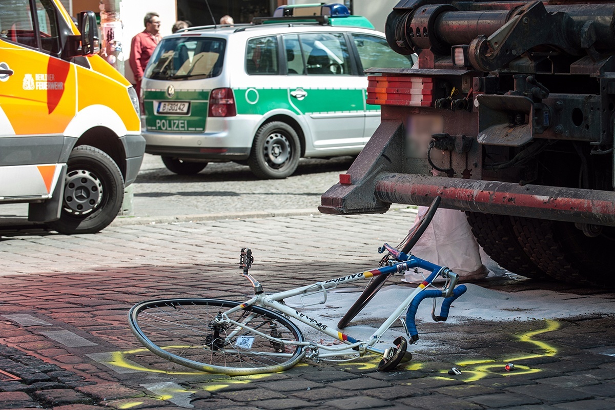 Ein demoliertes Fahrrad liegt auf der Straße, die Polizei hat die Umrisse mit Kreide markiert.