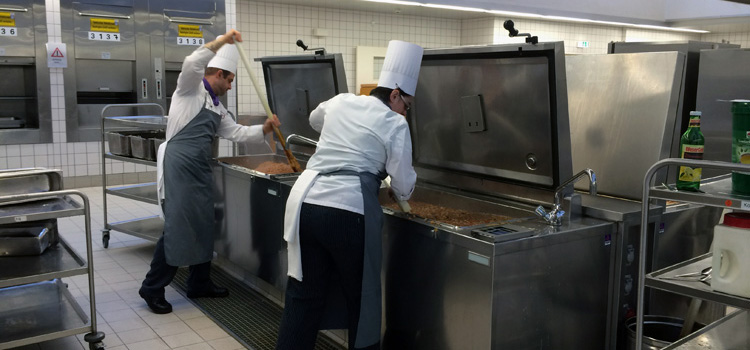 Übergroßes Kochen: Mit handels­üblichen Töpfen würden die Mitarbeiter der Mensa FU II nicht weit kommen. Bis zu 5500 Portionen bereiten sie täglich zu. Foto: Friederike Deichsler